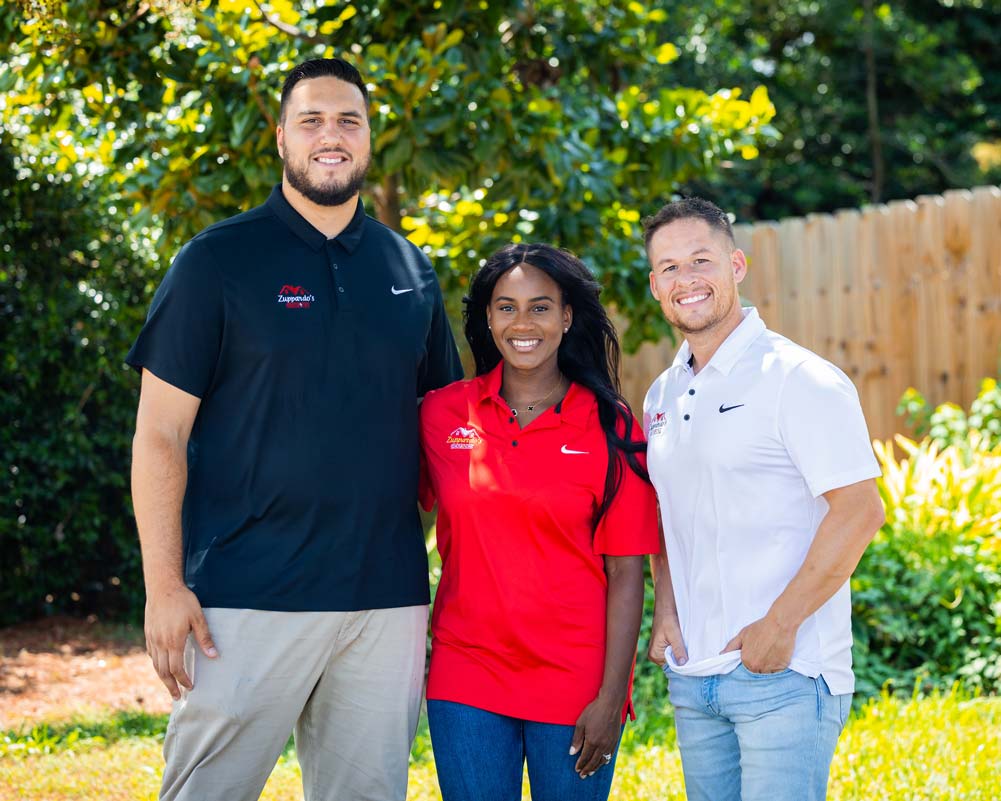 3 people smiling for outdoor group photo wearing Zuppardo's Renovations t-shirts